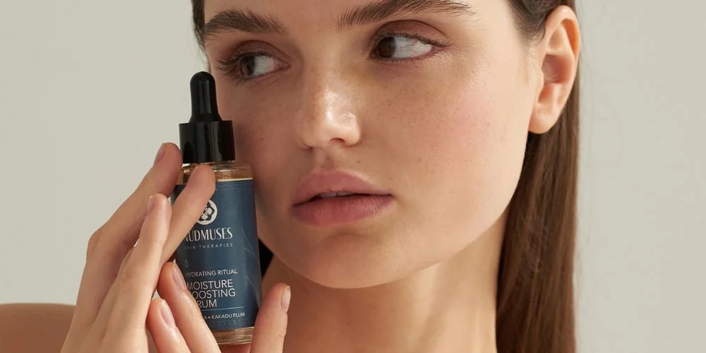 Żelowe serum nawilżające Nudmuses Hydrating Ritual, Moisture Boosting Serum trzymane przez modelkę